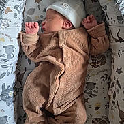 Gabriël participe au concours pour gagner de l'argent avec cette photo : newborn, baby, sleeping, onesie, hat, crib, cushion, pattern, animal_print, leaf_print, cozy, infant, cute, peaceful, indoor, bed, child, soft, resting, sleep