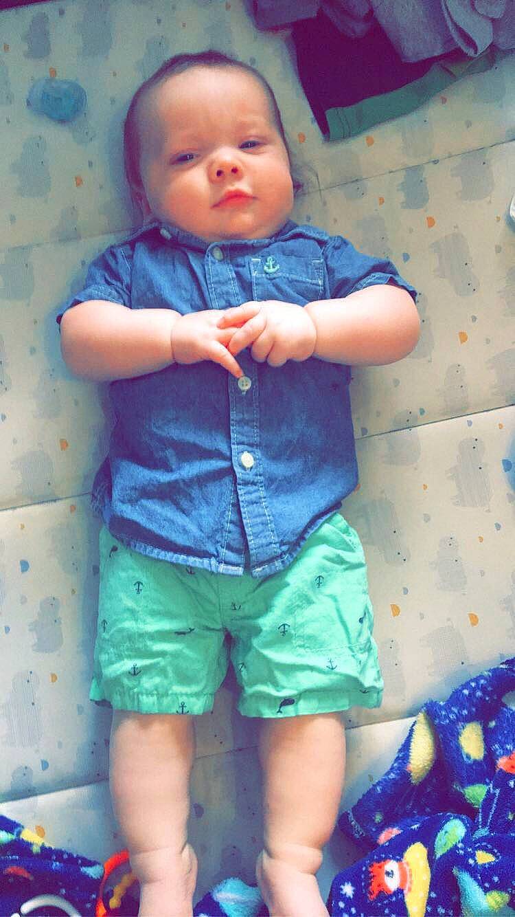 Emmitt is registered to the contest to win money with this photo: azure, baby, baby_toddler_clothing, blue, eye, face, green, human_body, mouth, nose, orange, person, photograph, pink, shorts, skin, sleeve, smile, standing, textile