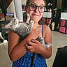 Bijoux participe au concours pour gagner de l'argent avec cette photo : affection, blue_dress, cat, cute, face, furniture, girl, glasses, holding, home, indoor, kitten, paw, person, pet, playful, shelf, smiling, storage, tile_floor