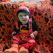 Tommy joined the competition — help win amazing prizes! baby, child, halloween, costume, orange, black, blanket, pumpkin, bat, spiderweb, spider, hat, booties, indoors, window, curtain, face, sitting, cute, festive