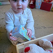 Tommy is registered to the contest to win money with this photo: baby, carpet, child, childhood, christmas, curious, cute, floor, gift_box, holiday, holiday_gifts, indoor, pajamas, person, plush_toy, present, soft_toy, stocking, toy, young_child