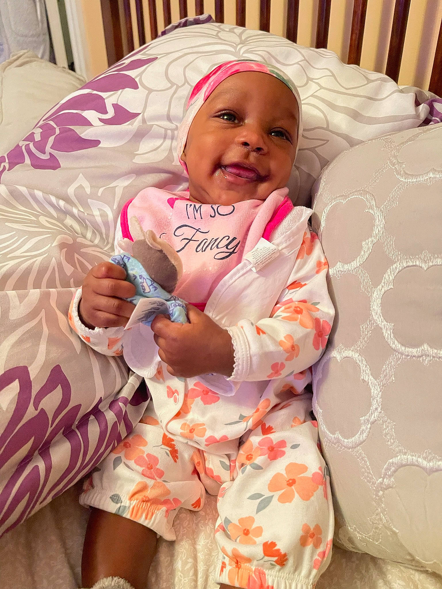 Kali Rae joined the competition — help win amazing prizes! baby, baby_toddler_clothing, bedding, child, comfort, facial_expression, finger, happy, headgear, headwear, linens, magenta, pattern, person, pink, skin, sleeve, smile, textile, thigh