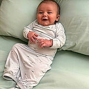Stetson is registered to the contest to win money with this photo: baby, infant, smiling, onesie, sailboat_pattern, couch, pillow, soft_fabric, relaxed, indoors, cute, child, person, portrait, comfort, happy, young, cozy, sitting, sock