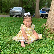 Emma joined the competition — help win amazing prizes! toddler, child, grass, yellow_dress, white_bow, outdoor, trees, truck, greenery, barefoot, cute, portrait, sitting, nature, daylight, lace, expression, young_child, park, sunlight