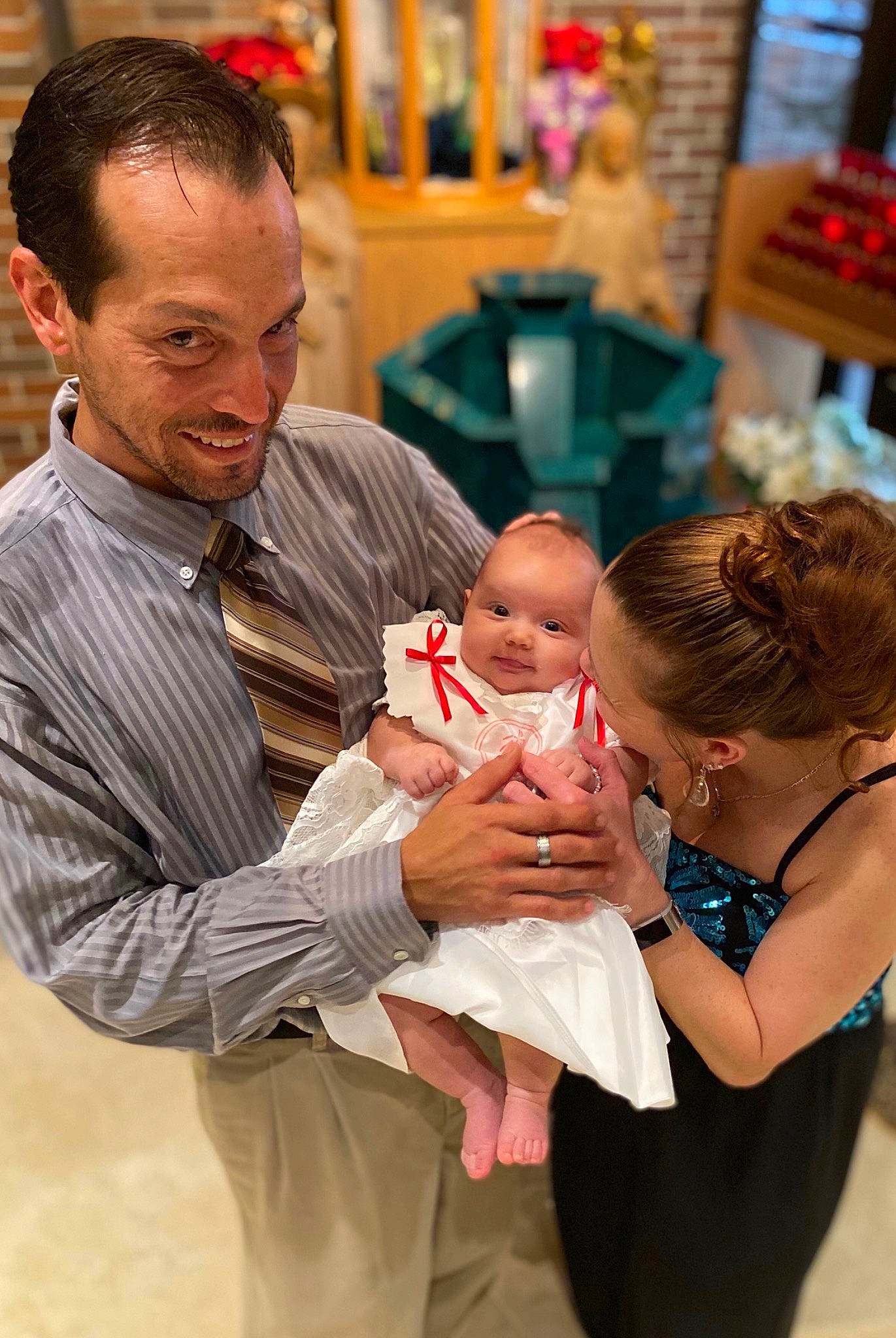 Terésa is registered to the contest to win money with this photo: baby, baptism, ceremony, child, daughter, event, family, father, joy, mother, people, person, ritual, toddler