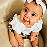 Kalani is registered to the contest to win money with this photo: accessories, baby, bow, chair, child, clothing, cute, face, fashion, girl, happy, headband, indoors, person, plaid_skirt, portrait, sandals, sitting, smile, white_top