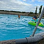 child, pool, water, swimming, inflatable, float, backyard, fence, sky, clouds, smile, summer, outdoor, play, fun, trees, grass, swing_set, headband, person