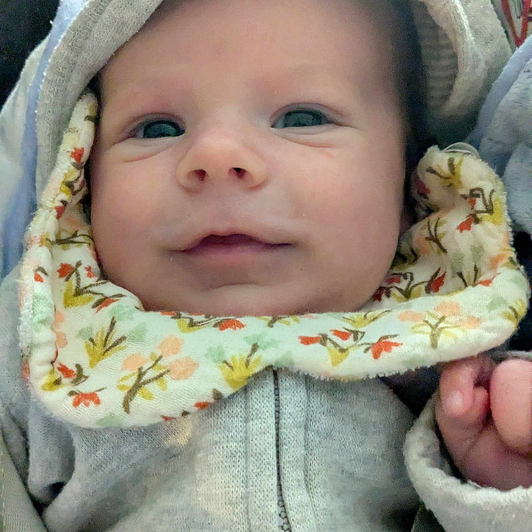 Valentin a rejoint le concours — aidez-le/la à gagner de superbes lots ! baby, baby_boy, baby_girl, bib, blue_blanket, child, closeup, clothing, cute, face, headwear, hoodie, indoor, infant, person, portrait, smile, soft_texture, warm_clothing, young