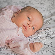 Giulia participe au concours pour gagner de l'argent avec cette photo : baby, infant, face, person, bed, blanket, fabric, pattern, pink_clothing, skin, head, hand, sleepwear, newborn, portrait, lying_down, soft_light, indoor, closeup, peaceful