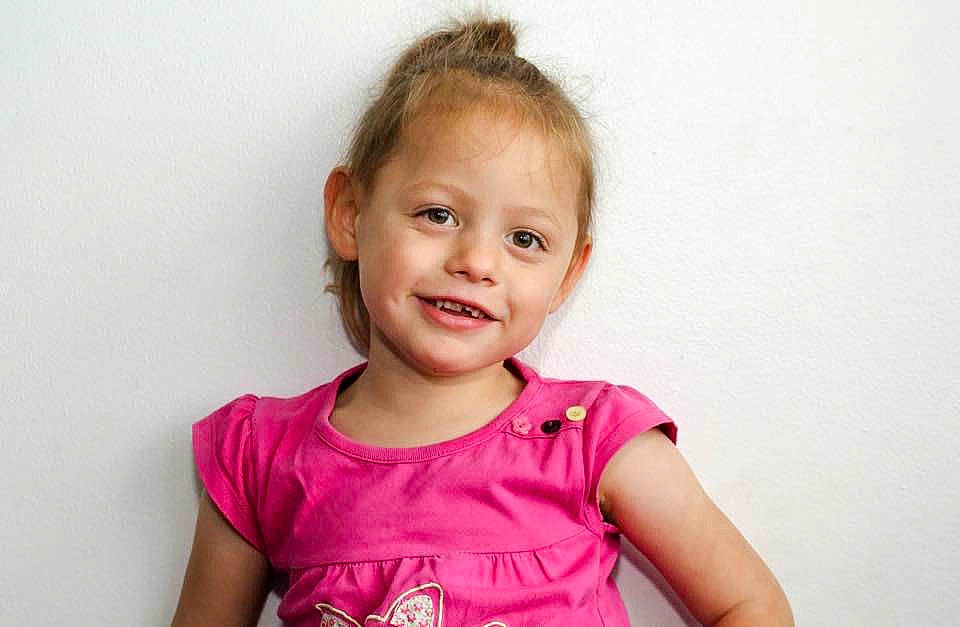 Nicole is registered to the contest to win money with this photo: arm, baby, cheek, child, child_model, ear, face, facial_expression, gesture, happy, head, neck, person, photography, pink, sitting, skin, smile, standing, t_shirt