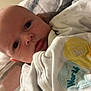 Arlo is registered to the contest to win money with this photo: baby, infant, face, eyes, onesie, clothing, blanket, bed, soft, cute, newborn, portrait, lying_down, child, indoors, warm, sleepwear, expression, skin, head