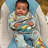 Gabriella joined the competition — help win amazing prizes! baby, baby_chair, bouncer, child, close_up, colorful_clothing, curly_hair, dark_hair, fleece_outfit, furniture, happy, harness, indoor, infant, photography, portrait, seated, smiling, toy, wood_floor