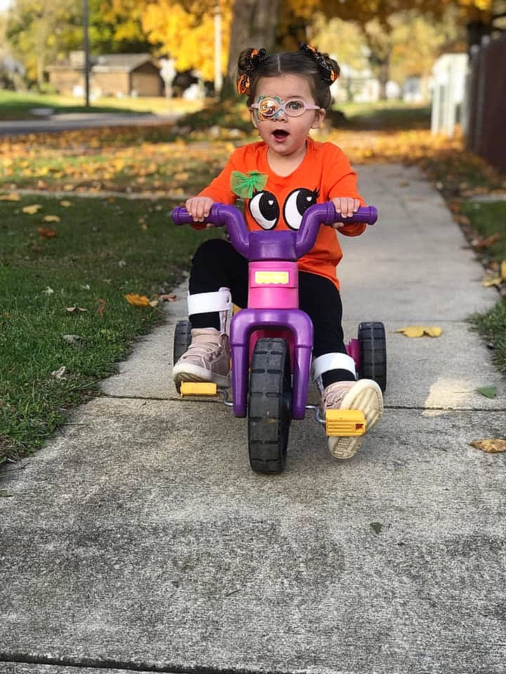 Kinleigh is registered to the contest to win money with this photo: automotive_wheel_system, child, person, play, recreation, riding_toy, smile, surprise, toddler, training_wheels, tricycle, vehicle, wheel