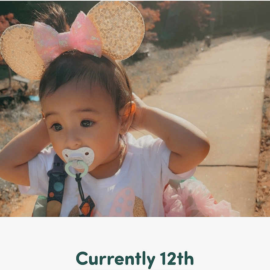 Angela is registered to the contest to win money with this photo: toddler, child, pacifier, mouse_ears, headband, outdoor, sidewalk, sunlight, curious, voting, campaign, text_overlay, clothing, person, portrait, nature, autumn, hair, cute, baby
