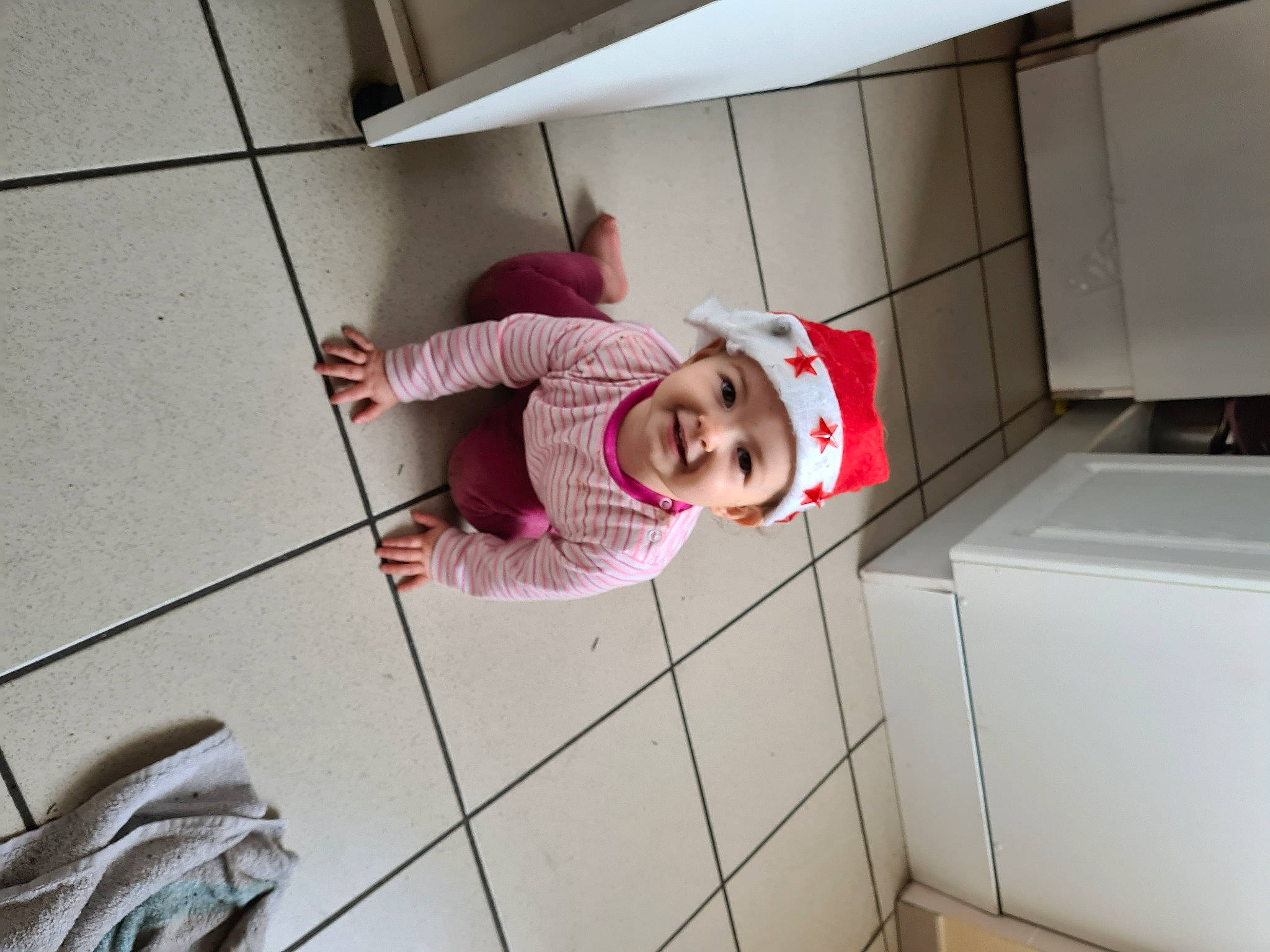 Léana a rejoint le concours — aidez-le/la à gagner de superbes lots ! baby, cabinetry, child, floor, flooring, fun, hat, headwear, joy, kitchen_appliance, person, room, selfie, smile, t_shirt, tile, toddler, wood