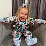 toddler, child, smiling, happy, sitting, armchair, indoor, curtains, colorful_clothing, bow, blonde_hair, playful, cute, feet, sock, patterned_outfit, butterfly, young_child, joyful, portrait