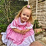 Dottie joined the competition — help win amazing prizes! child, girl, pink_dress, flower_hair_clip, smiling, outdoor, garden, wooden_fence, greenery, portrait, cute, happy, face, hair, nature, crouching, young_child, playful, daylight, casual