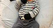 Jakel is registered to the contest to win money with this photo: baby, child, cozy, cushion, cute, expression, face, feet, hands, hat, indoor, infant, mittens, newborn, pajamas, portrait, resting, sitting, soft_surface, striped_clothing