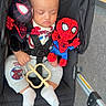 baby, stroller, plush_toy, spiderman, sleeping, child, toy, infant, clothing, socks, seatbelt, black_stroller, hand, floor, red, toy_accessory, cute, peaceful, indoors, portrait