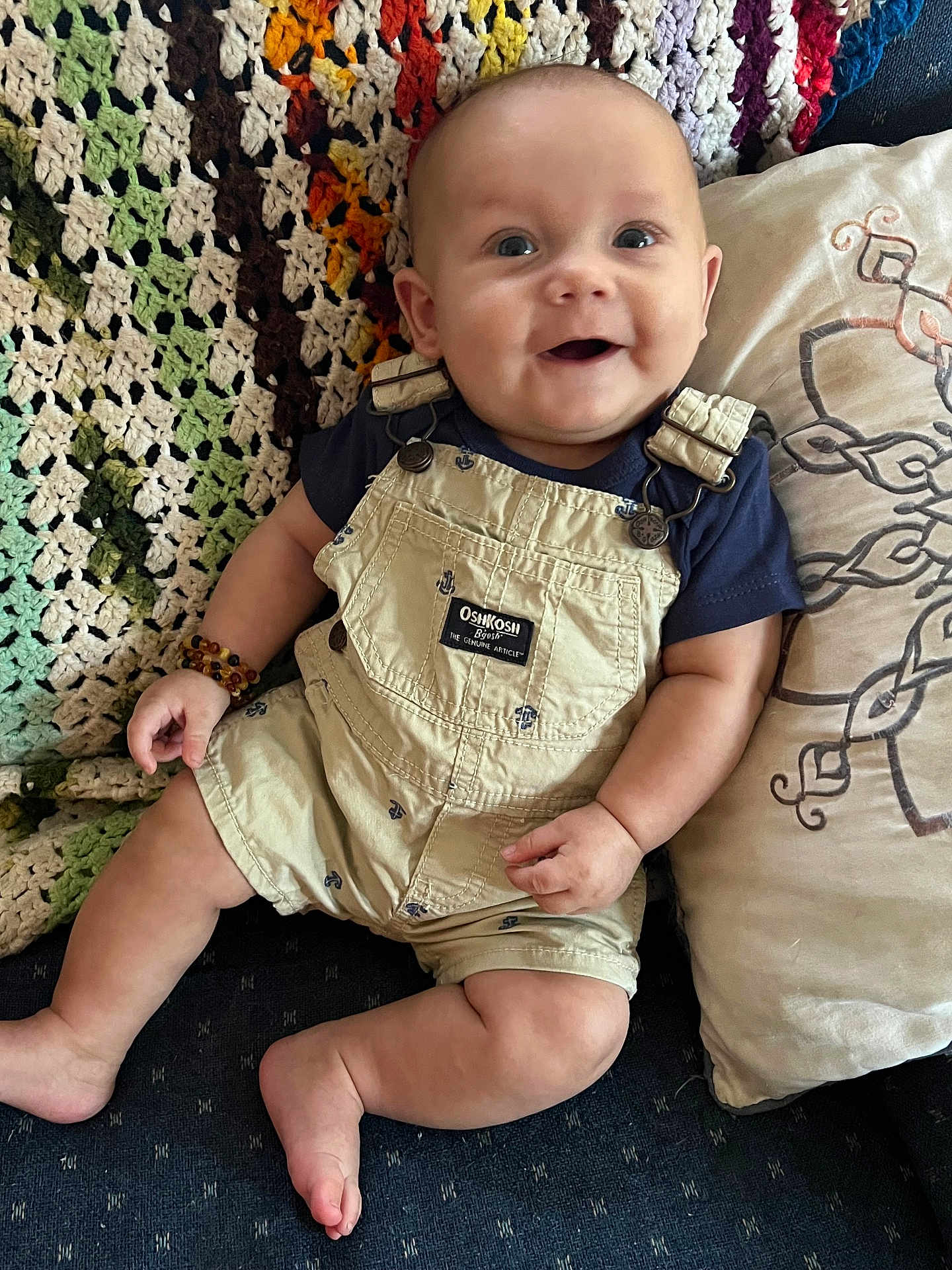 Kazdyn joined the competition — help win amazing prizes! baby, smiling, infant, overalls, crocheted_blanket, pillow, sitting, happy, clothing, face, person, indoor, cute, skin, foot, hand, head, blue_shirt, fabric, comfortable