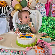 Brayleanna joined the competition — help win amazing prizes! toddler, child, birthday_cake, high_chair, messy_face, green_dress, balloons, giraffe_decoration, gift_bags, party, celebration, cake, table, face, hands, colorful, decorations, indoor, smudged_icing, happy
