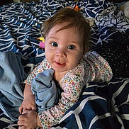 Brayleanna is registered to the contest to win money with this photo: baby, child, infant, bed, blanket, blue, clothing, cute, face, floral_pattern, hand, indoors, laying, person, plush, portrait, smiling, toy, young, sleepwear