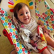 Brayleanna joined the competition — help win amazing prizes! baby, child, infant, smile, face, person, seat, baby_seat, blanket, clothing, colorful, pattern, circles, happy, indoors, floor, foot, skin, comfort, portrait