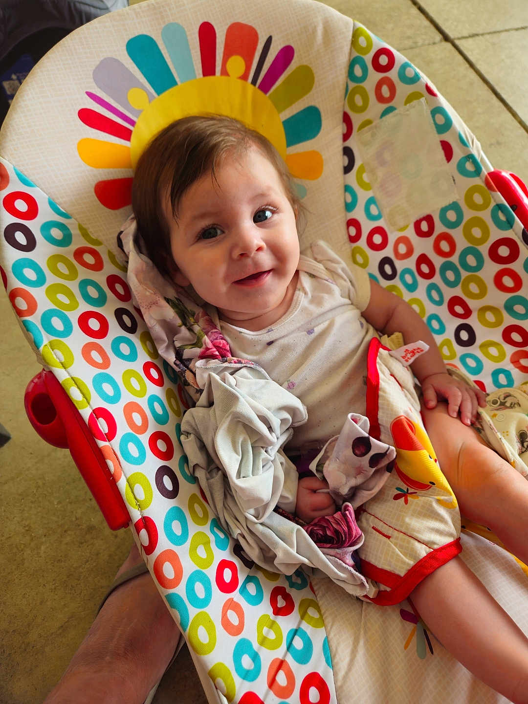 Brayleanna joined the competition — help win amazing prizes! baby, child, infant, smile, face, person, seat, baby_seat, blanket, clothing, colorful, pattern, circles, happy, indoors, floor, foot, skin, comfort, portrait
