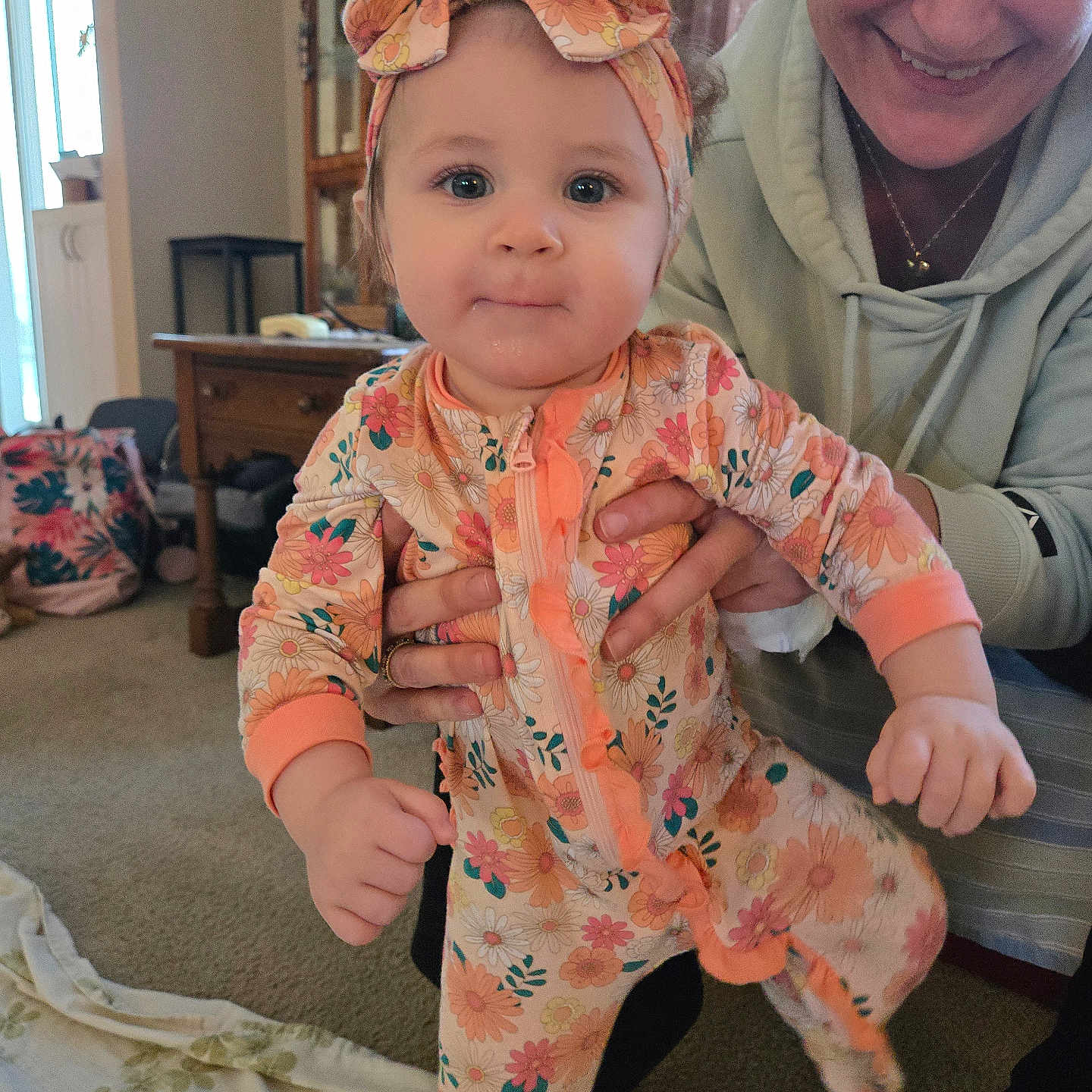 Brayleanna joined the competition — help win amazing prizes! baby, blanket, cabinet, carpet, child, curtains, family, floral_pattern, furniture, hand, happy, headband, indoor, lamp, living_room, onesie, person, portrait, smile, woman