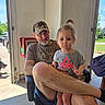 cap, casual, chair, child, dog, door, expression, face, garage, hair, indoor, legs, man, person, shorts, sitting, socks, sunlight, tshirt, window