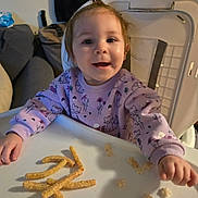 Brayleanna joined the competition — help win amazing prizes! baby, cereal, cheese_puffs, child, couch, face, fox_pattern, furniture, hair, hand, happy, highchair, indoor, living_room, portrait, purple_sweater, seat, smile, snack, tray