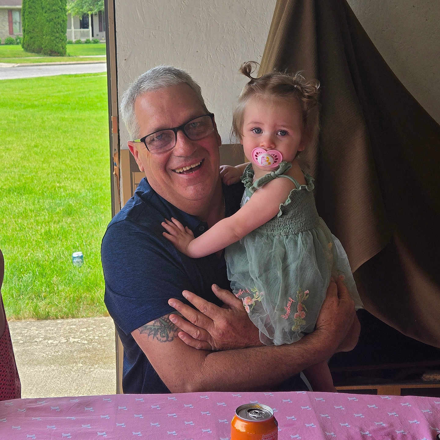 Brayleanna joined the competition — help win amazing prizes! man, child, toddler, glasses, pacifier, dress, greenery, table, can, phone, indoor, window, smile, hair, pigtails, tattoo, happy, person, family, portrait