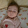 baby, butterfly_pattern, calm, child, closed_eyes, cozy, cute, face, head, heart_design, indoors, peaceful, pillow, pink_clothing, portrait, resting, sleeping, soft_lighting, toddler, young_child