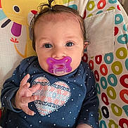Brayleanna is registered to the contest to win money with this photo: baby, pacifier, blue_shirt, heart_pattern, pony_tail, infant, baby_seat, colorful, polka_dots, smiling_sun, multicolored_circles, cute, indoors, child, portrait, hand, face, clothing, comfort, happy