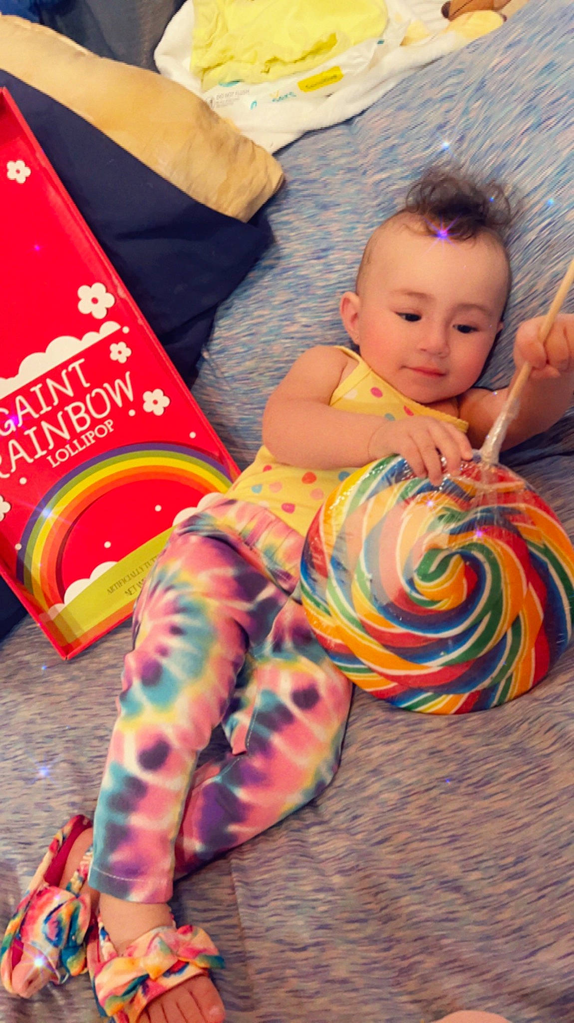 Kara is registered to the contest to win money with this photo: baby, baby_toddler_clothing, child, comfort, event, flooring, foot, fun, happy, human_leg, leg, leisure, linens, orange, person, pink, play, sitting, textile, thigh