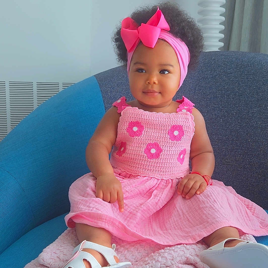 Miley joined the competition — help win amazing prizes! baby, child, pink_dress, headband, bow, sitting, blue_chair, blanket, smiling, indoors, cute, footwear, curly_hair, portrait, infant, fashion, soft_texture, happy, toddler, cozy