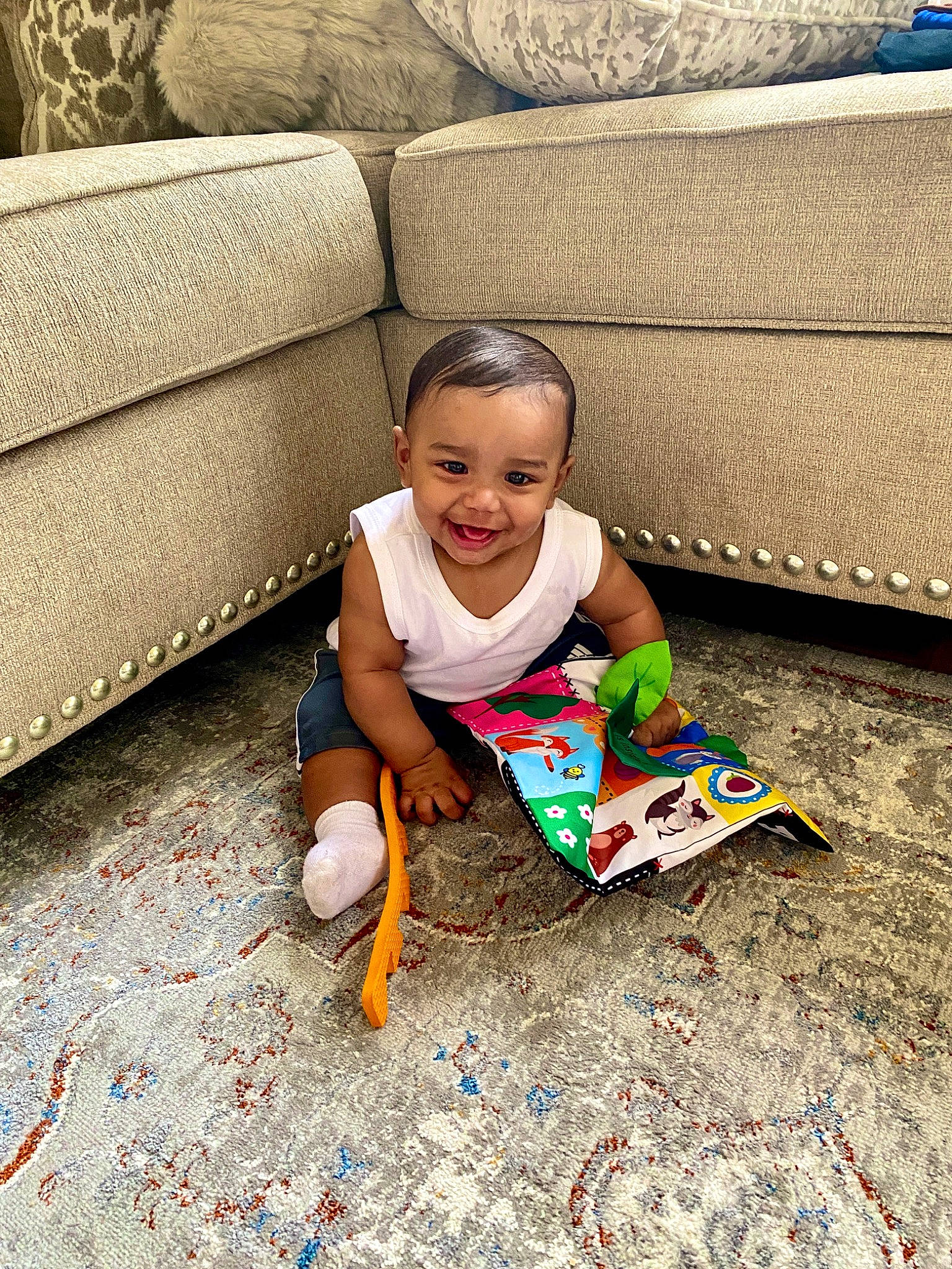 Ian Manuel Florentino is registered to the contest to win money with this photo: baby_toddler_clothing, child, comfort, couch, floor, flooring, foot, grass, happy, hardwood, head, human_body, human_leg, joy, leisure, person, sitting, smile, t_shirt, toddler