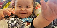 Amber joined the competition — help win amazing prizes! baby, car_seat, child, clothing, colorful, curly_hair, cute, fabric, face, hand, happy, indoor, infant, light, person, portrait, seat, smile, toy, window