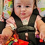 Amber is registered to the contest to win money with this photo: baby, child, car_seat, curly_hair, drool, floral_pattern, toy, colorful, black_straps, pink_clothing, cute, infant, seat_belt, zebra_sock, denim_pants, indoor, portrait, person, closeup, cute_face