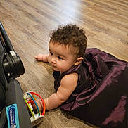 Amber joined the competition — help win amazing prizes! arm, baby, child, colorful_toy, crawling, curly_hair, cute, dress, earrings, floor, flooring, indoor, infant, person, playing, purple_dress, smiling, stroller, toy, wooden_floor