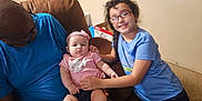 Savannah joined the competition — help win amazing prizes! adult, baby, blue_shirt, carpet, casual, child, couch, family, furniture, glasses, happy, headband, holding, home, indoor, person, pink_clothing, room, sitting, smile