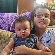 Savannah joined the competition — help win amazing prizes! baby, child, colorful_clothing, couch, cozy, crocheted_blanket, curly_hair, cute, family, glasses, happy, holding, home, indoor, people, portrait, seated, sibling, smiling, together