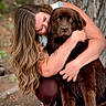 person, dog, hug, outdoor, tree, nature, brown_dog, affection, love, pet, animal, long_hair, casual_clothing, sandals, close_up, portrait, happy, companionship, friendship, warmth