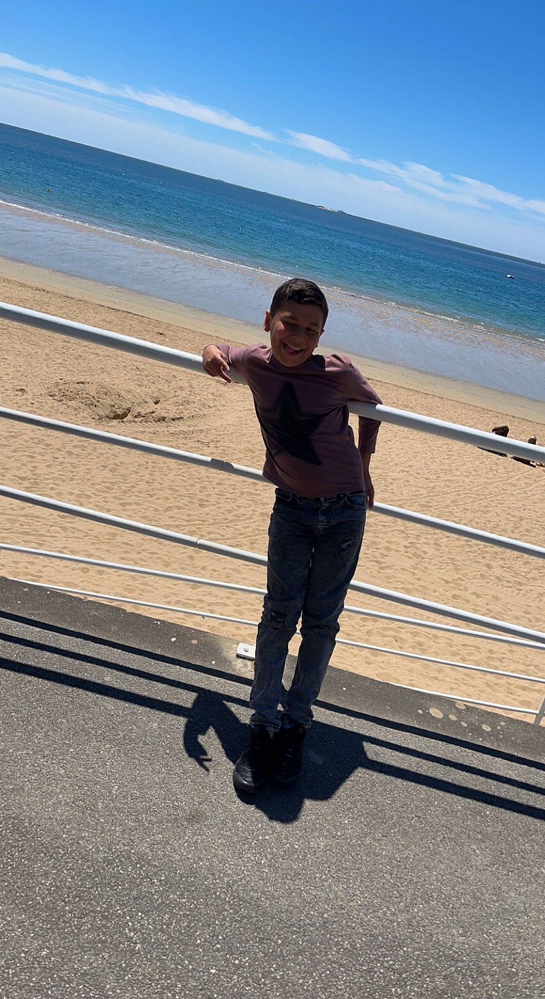 Yanis a rejoint le concours — aidez-le/la à gagner de superbes lots ! beach, calm, cloud, electric_blue, fence, fun, gesture, happy, horizon, human_body, human_leg, joy, leisure, people_in_nature, people_on_beach, person, shore, sky, standing, travel