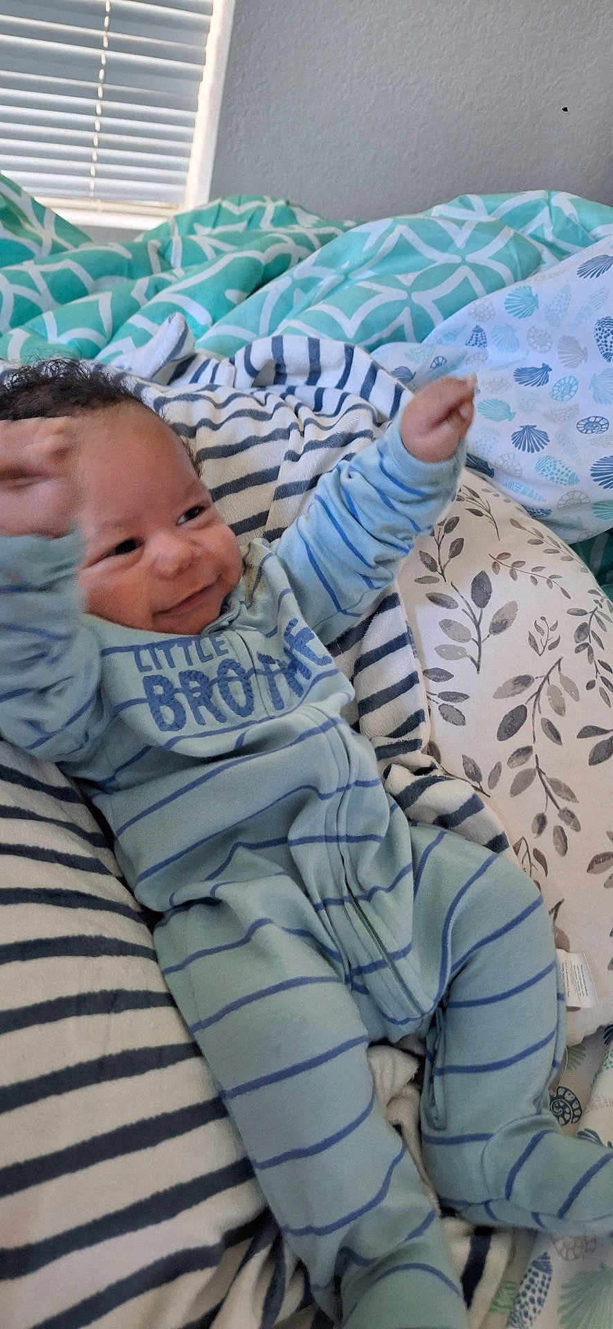 Ny'Gel joined the competition — help win amazing prizes! baby, bed, blanket, blue_clothing, child, cozy, curly_hair, face, happy, indoor, infant, lying_down, patterned_fabric, person, pillow, raising_arms, sleepwear, smiling, striped_clothing, toddler