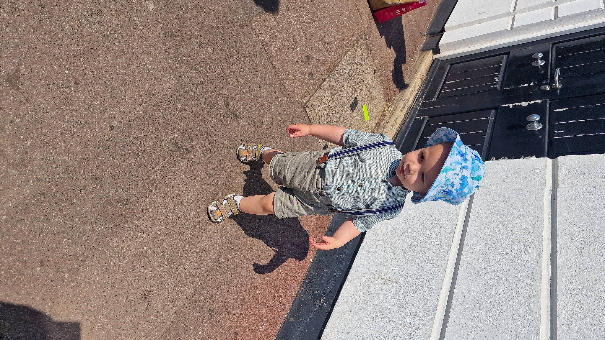 Albert is registered to the contest to win money with this photo: asphalt, city, concrete, foot, fun, headwear, human_leg, leisure, outdoor_shoe, pedestrian, person, recreation, road, road_surface, sandal, shadow, shorts, sidewalk, sitting, street