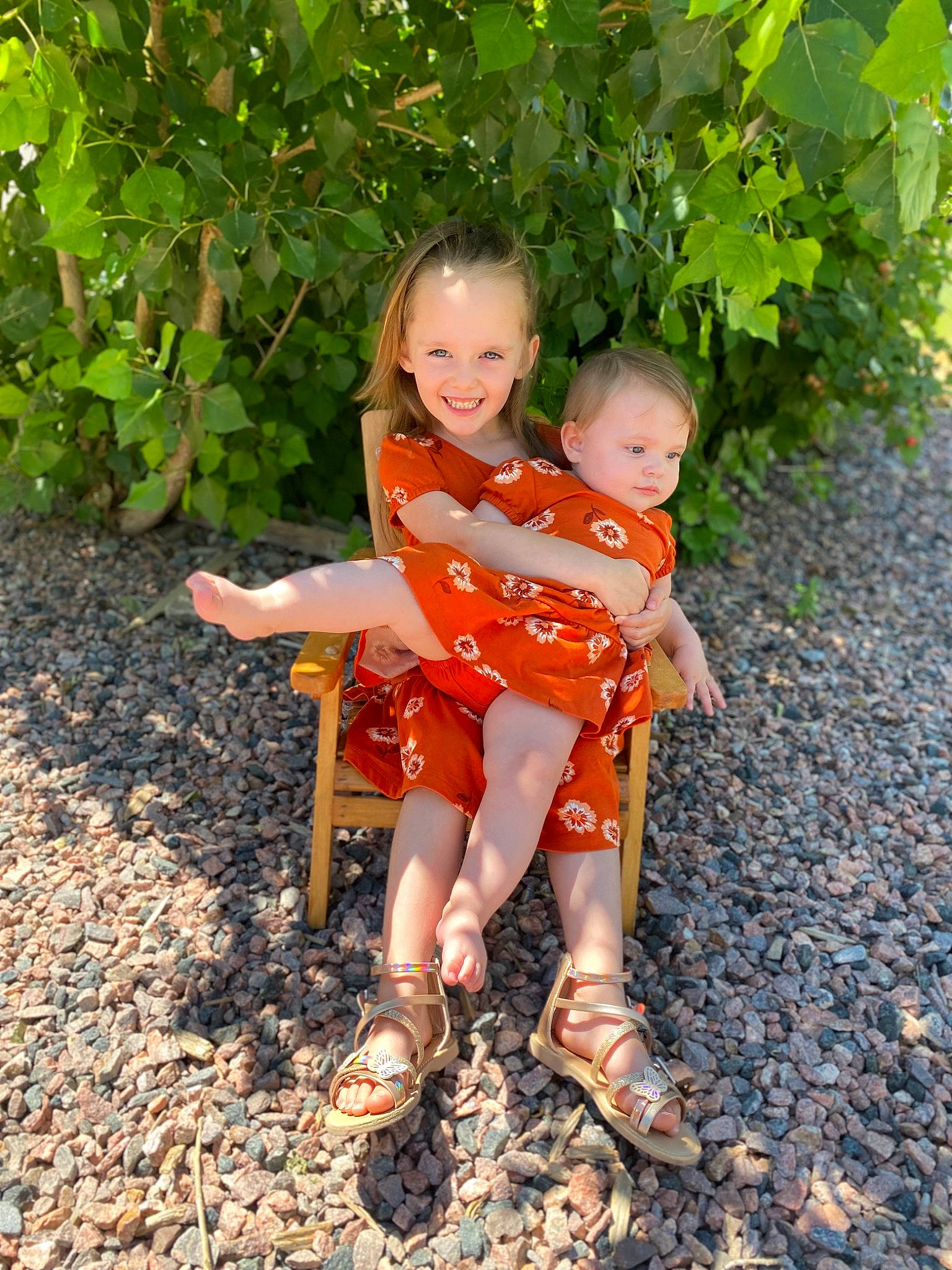 Charlotte is registered to the contest to win money with this photo: adaptation, baby_toddler_clothing, foot, footwear, fruit, fun, grass, happy, head, human_leg, joy, leisure, orange, people_in_nature, person, plant, sandal, shorts, smile, sneakers