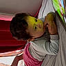 Enma joined the competition — help win amazing prizes! child, toddler, tablet, bed, blanket, cartoon, curly_hair, indoor, pink_skirt, long_sleeve_shirt, watching, screen, foot, remote_control, curtains, window, cozy, laying_down, focused, soft_light