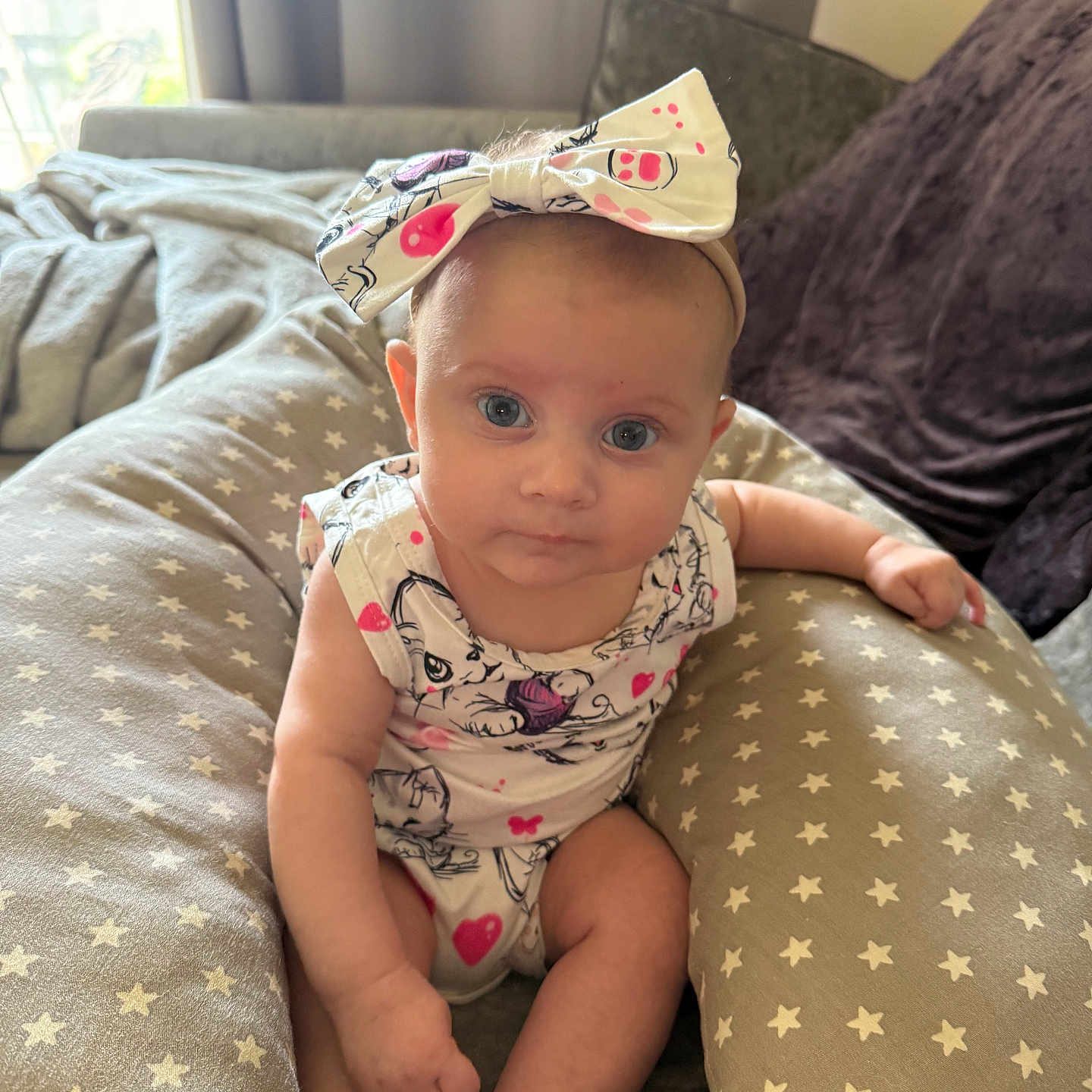 Anabella joined the competition — help win amazing prizes! baby, blue_eyes, bow, child, clothing, curious, cushion, cute, foot, hand, headband, indoor, infant, natural_light, person, portrait, sitting, skin, soft_fabric, star_pattern