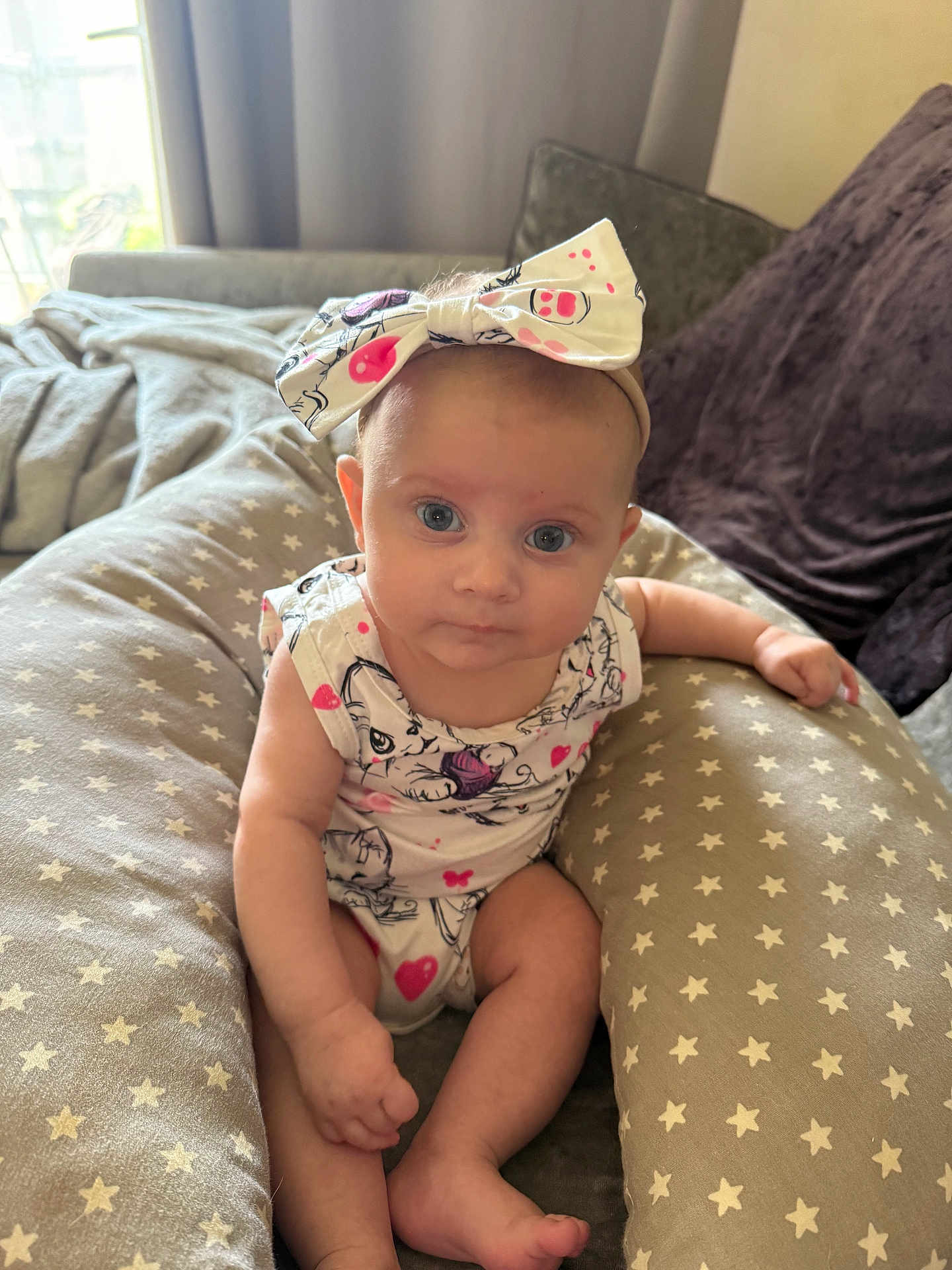 Anabella joined the competition — help win amazing prizes! baby, infant, child, headband, bow, blue_eyes, cushion, star_pattern, sitting, indoor, natural_light, curious, cute, clothing, soft_fabric, person, portrait, skin, hand, foot
